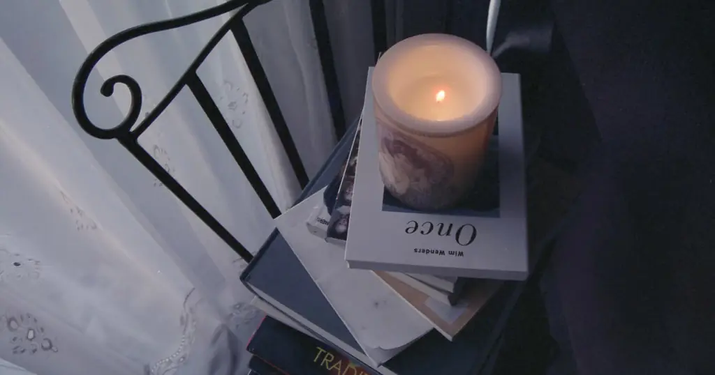 Bougie à côté d'une pile de livres